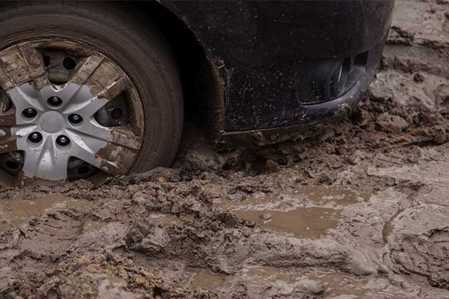 Roda de um carro atolado na lama