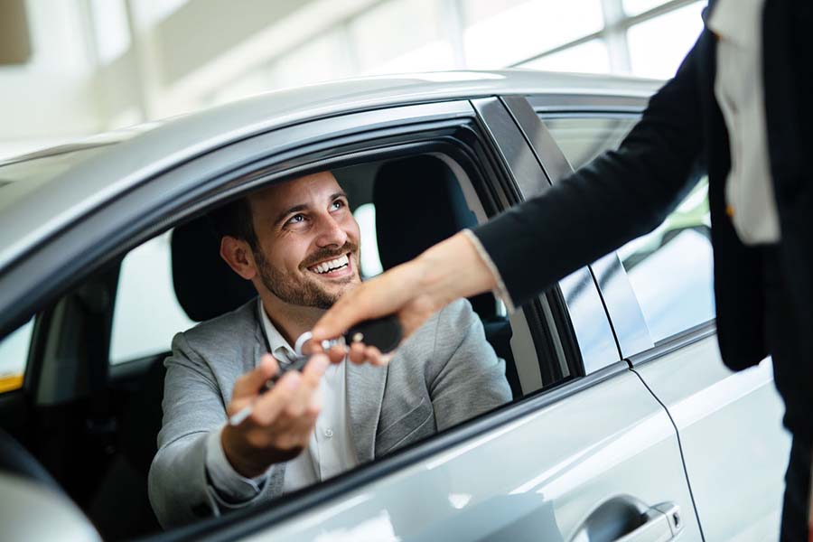 Na imagem um homem está dentro de um dos carros mais vendidos em 2019 e segura uma chave