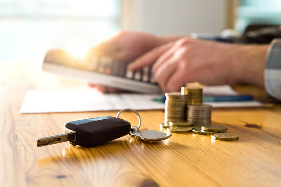 Na imagem é possível ver uma mesa com moedas e uma chave de um dos carros mais vendidos