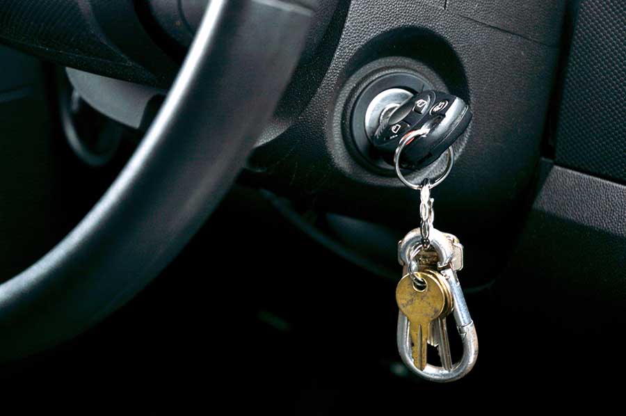 Existe uma chave dentro do carro posicionada na ignição com um chaveiro de metal