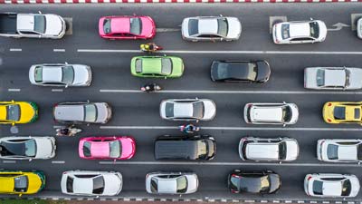 diversos carros enfileirados no trânsito em uma imagem de cima