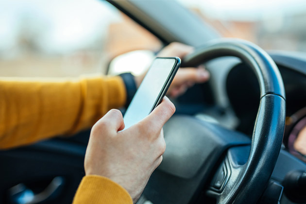 Vemos um motorista de app com telefone na mão. Veja dicas para cuidar melhor do carro!