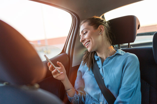 Vemos uma passageira feliz em um carro limpo. Confira dicas para cuidar melhor do carro!