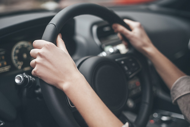 Pessoa com as mãos no volante tremendo. Saiba quais são os principais motivos!