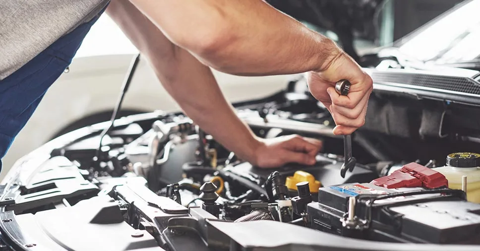 Mecânico mexendo no sistema de arrefecimento do carro