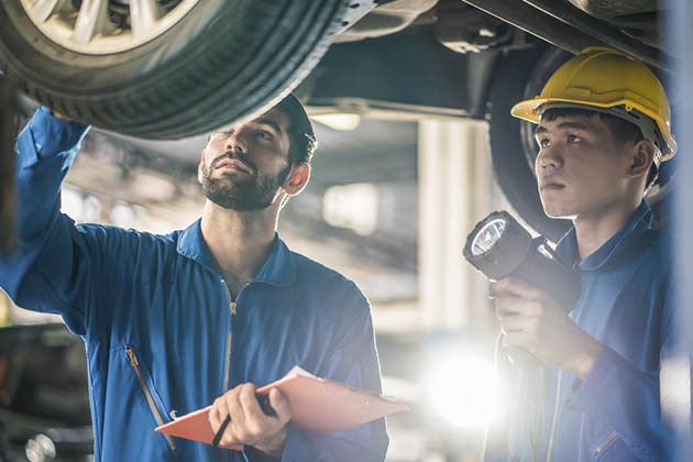 Dois homens olhando para a roda no rebaixamento de carro
