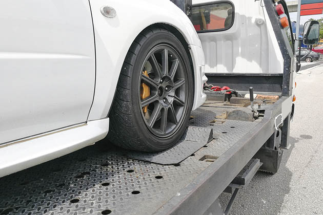 Um carro atolado sendo rebocado por um guincho