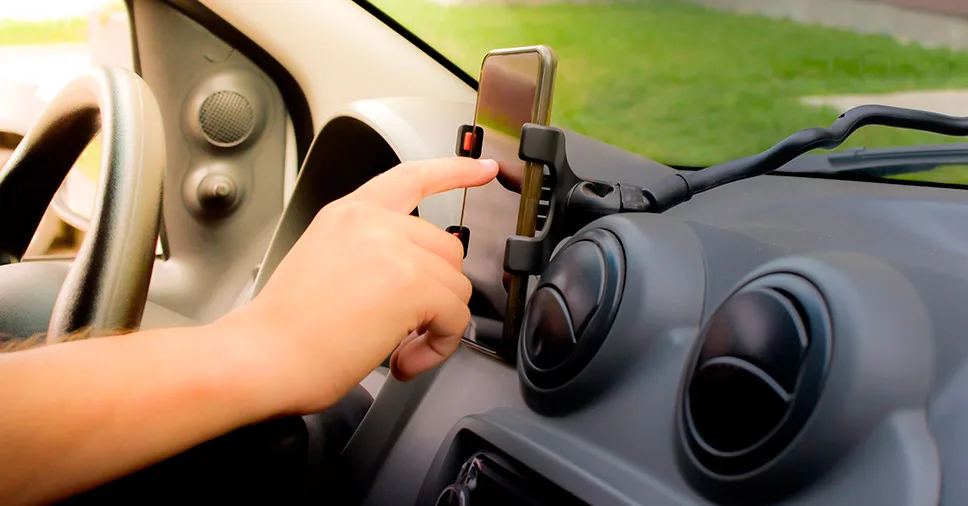 Na imagem vemos o motorista de aplicativo verificando algo no telefone.