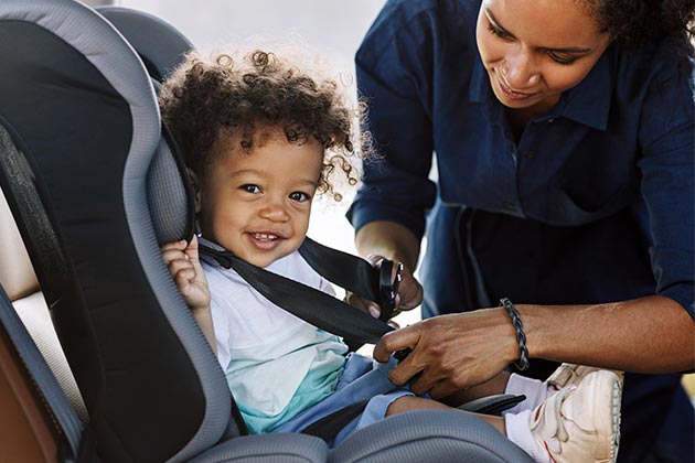 Vemos uma mãe que sabe como transportar crianças com segurança.