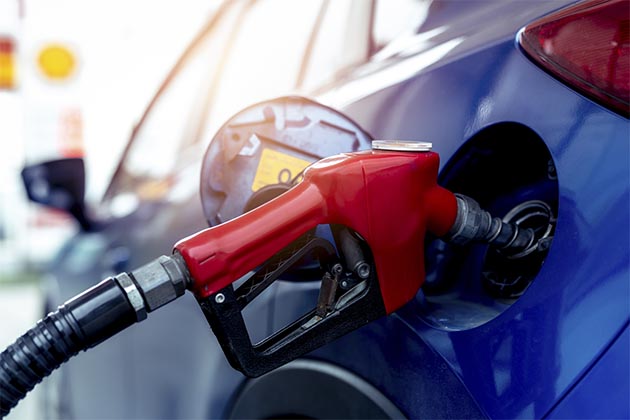 Uma pessoa botando combustível no veículo. Verificar seu nível é um dos cuidados diários importantes.