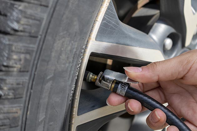 Uma pessoa calibrando o pneu. Esse é um dos cuidados diários necessários ao veículo.