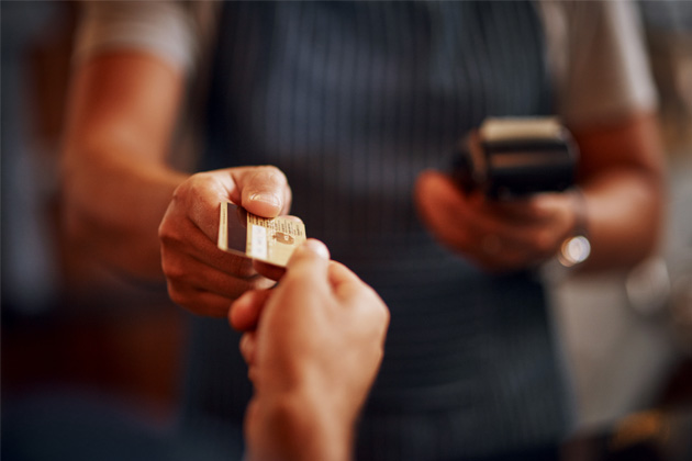 Vemos uma pessoa pagando pelo serviço econômico da cooperativa de proteção veicular.
